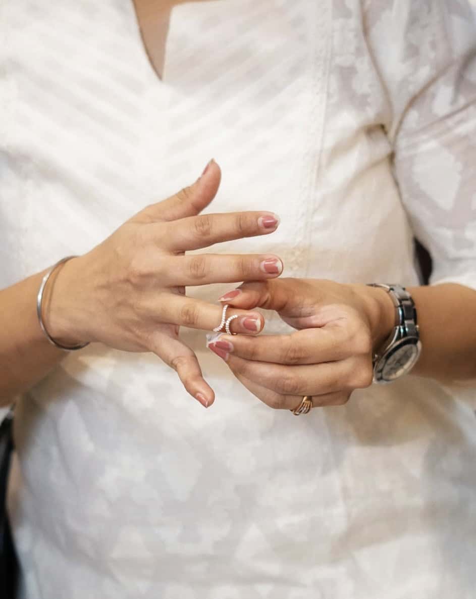 Double wave Ring on woman's finger, showcasing elegant design.