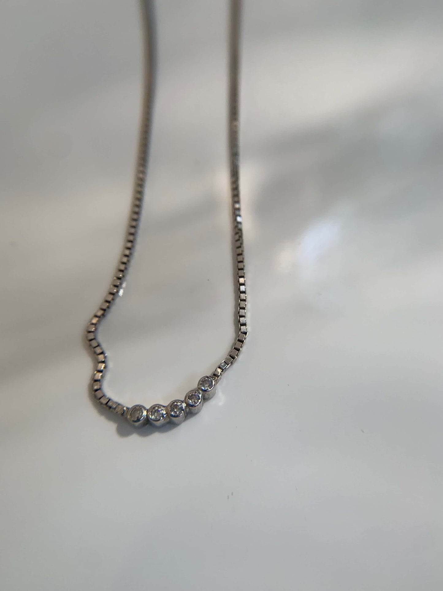Elegant Five Dot Curved Pendant on a delicate chain.