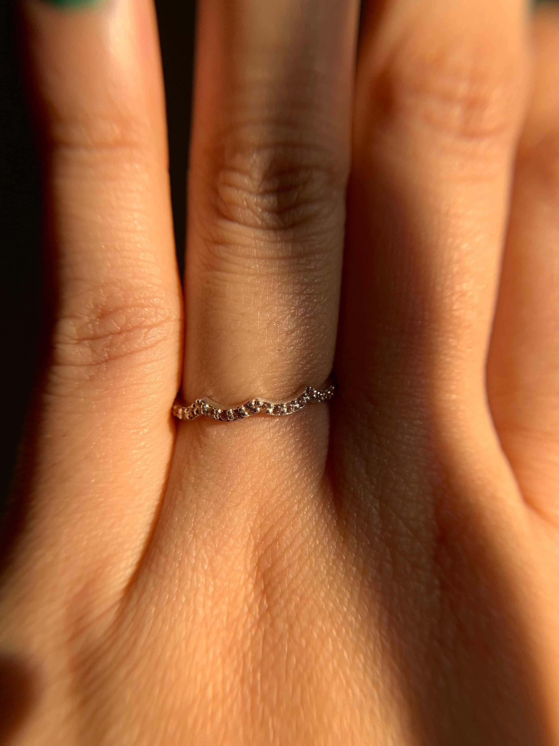 Three Peak Ring on a finger in soft lighting.