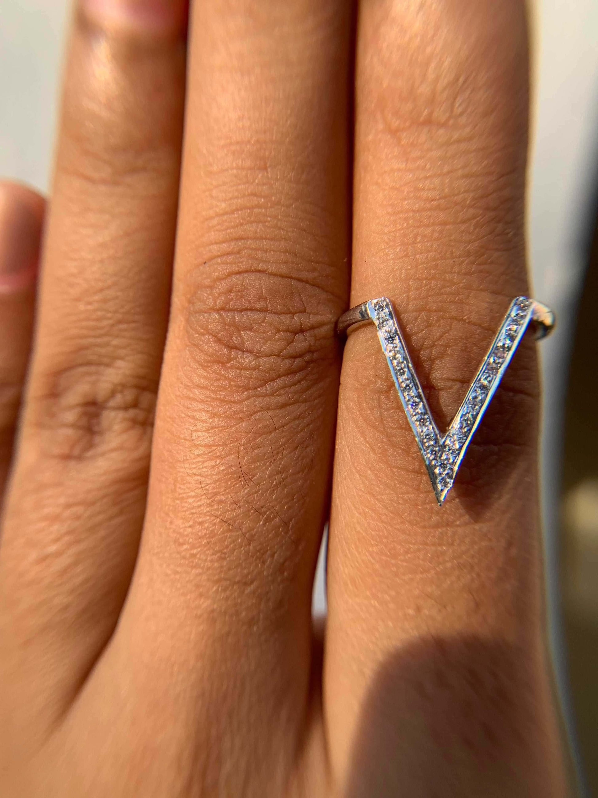 Silver V Ring on a finger showcasing its unique design.