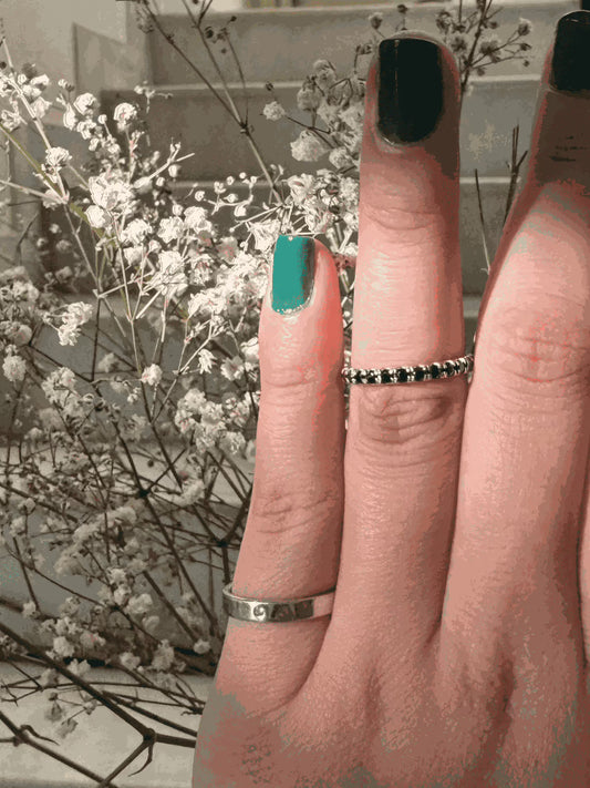 Thin Diamond Line Ring on Finger with Floral Background