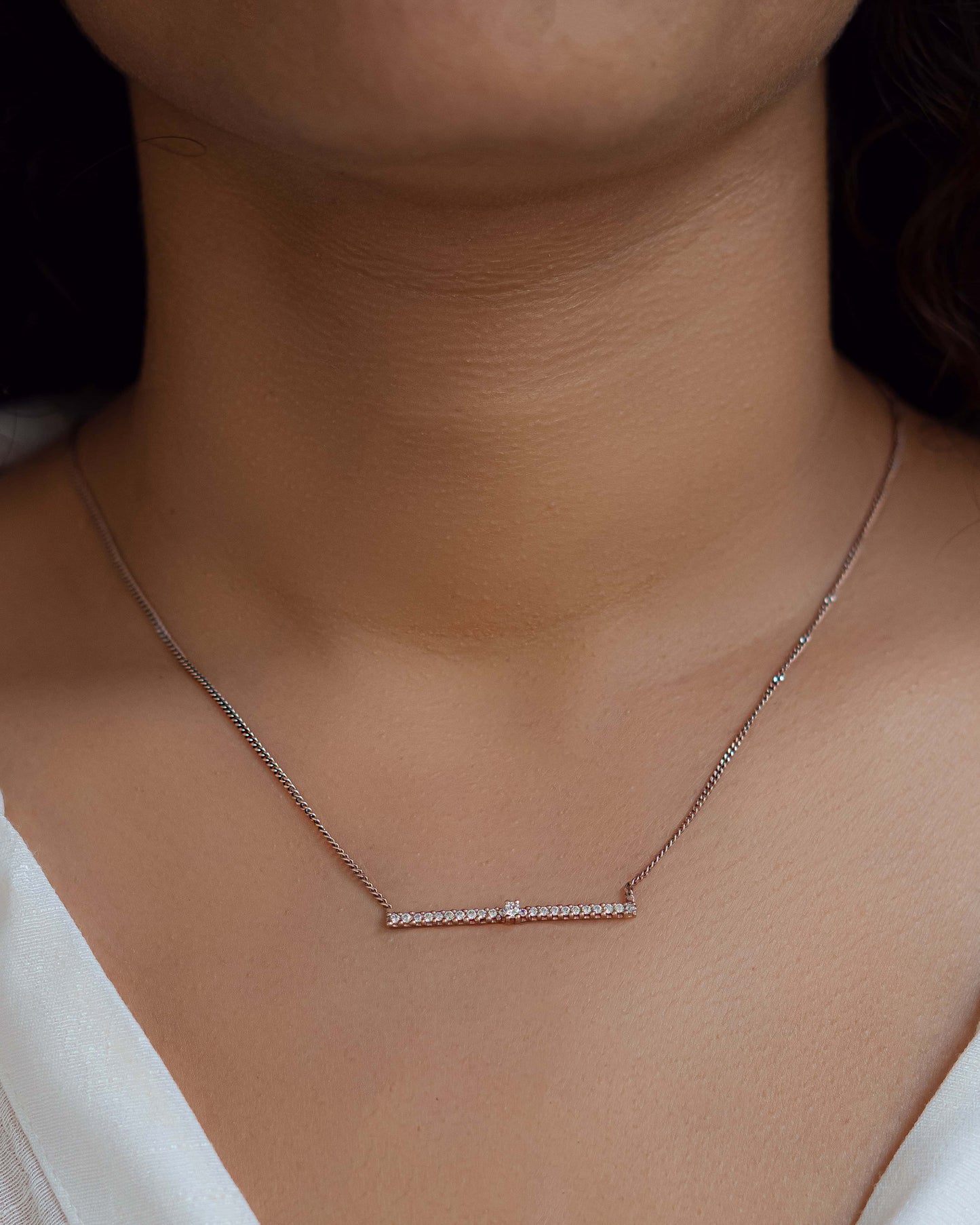 Line Pendant necklace worn around the neck.