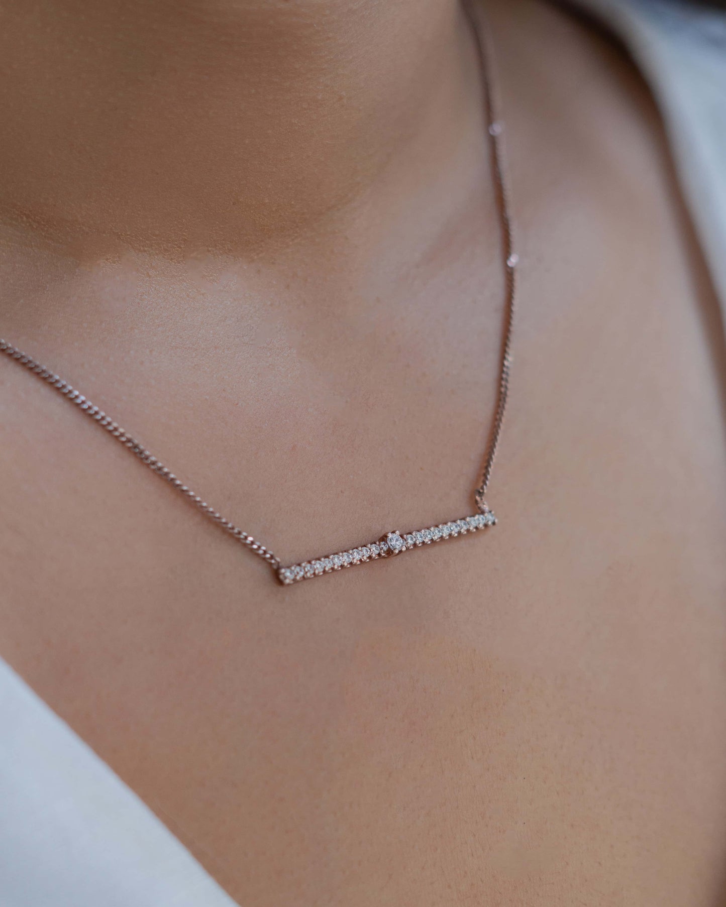 Line Pendant necklace on a person's neck.