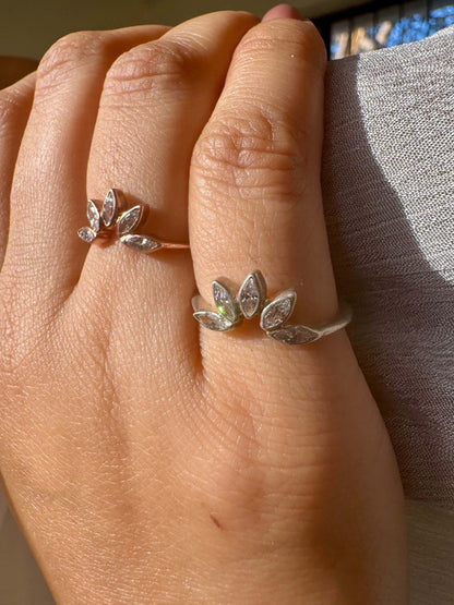 Silver sunflower ring on hand with light reflections.