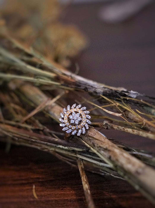 Yellow cocktail ring with intricate design placed on rustic twigs.
