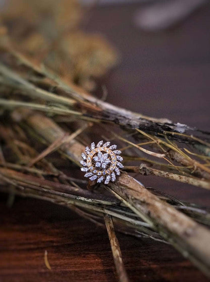 Yellow cocktail ring with intricate design placed on rustic twigs.