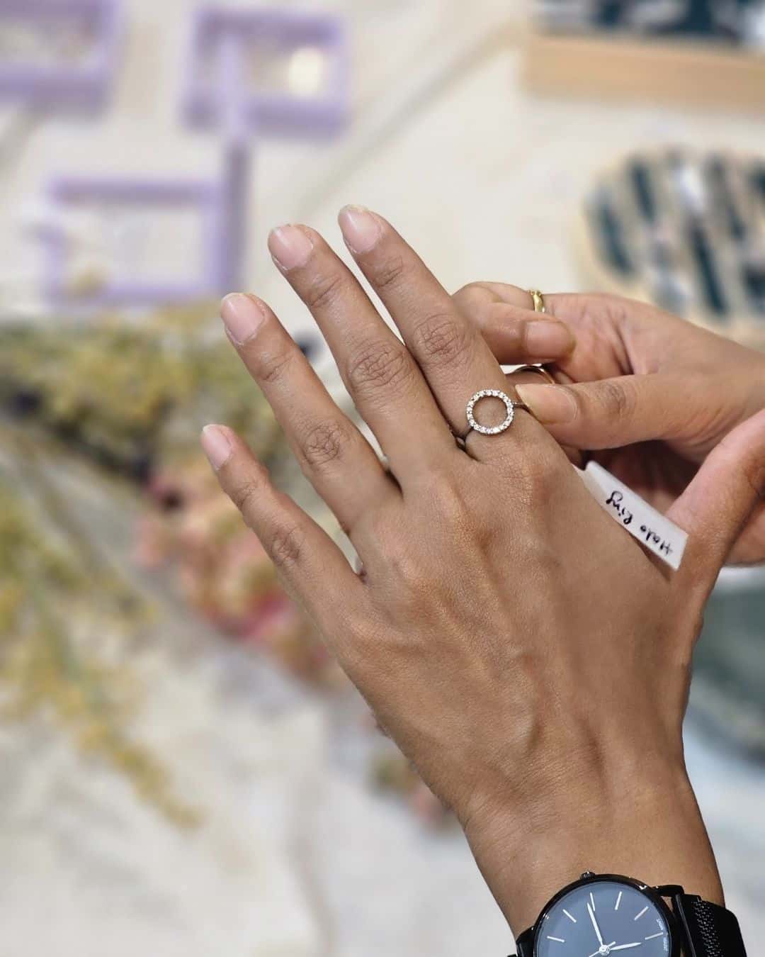 Elegant halo ring on woman's hand.