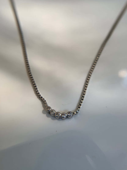 Five Dot Curved Pendant on a delicate chain.