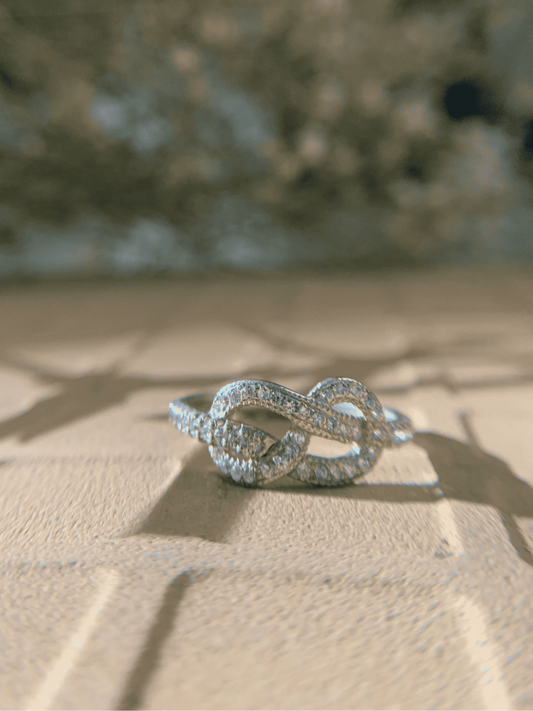 Diamond-studded infinity ring in sunlight.