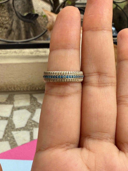 Gold ring with blue line on finger.