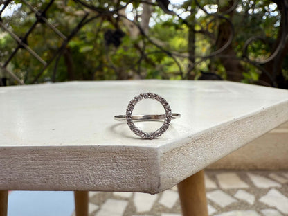 Halo Ring with sparkling gems on a round outdoor table.