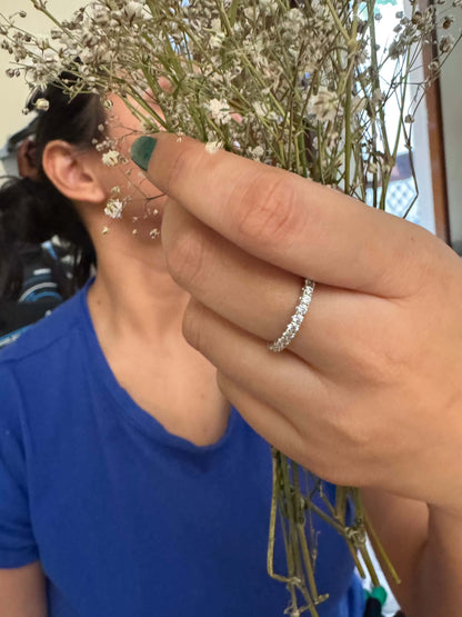 Classic Shine Line Ring displayed on hand holding delicate flowers.