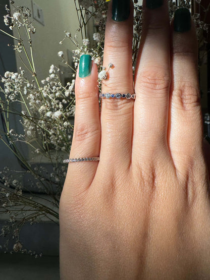 Classic Shine Line Ring on finger with delicate floral backdrop.